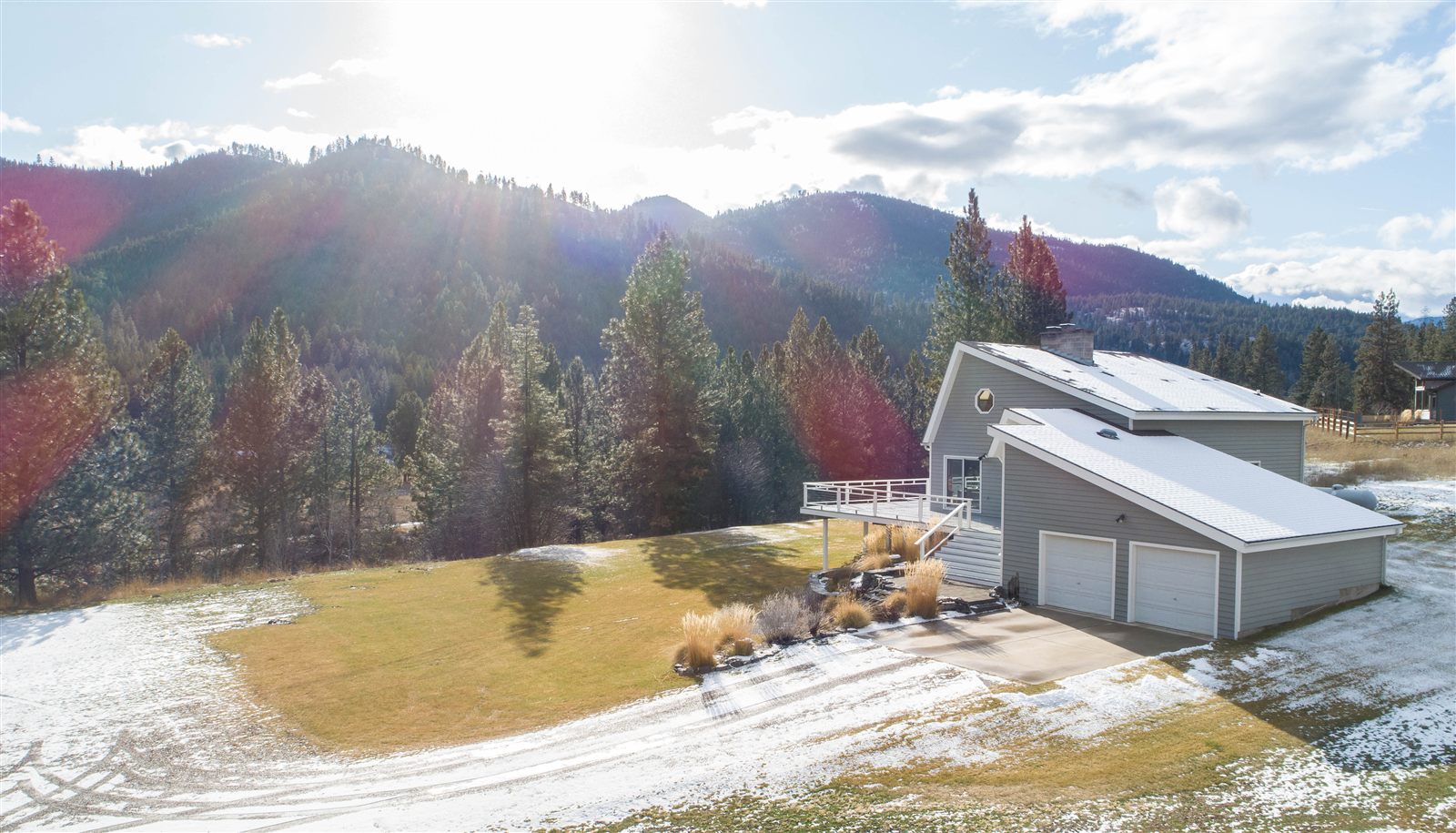 Aerial view of a hillside home and acreage with mountain views near Missoula