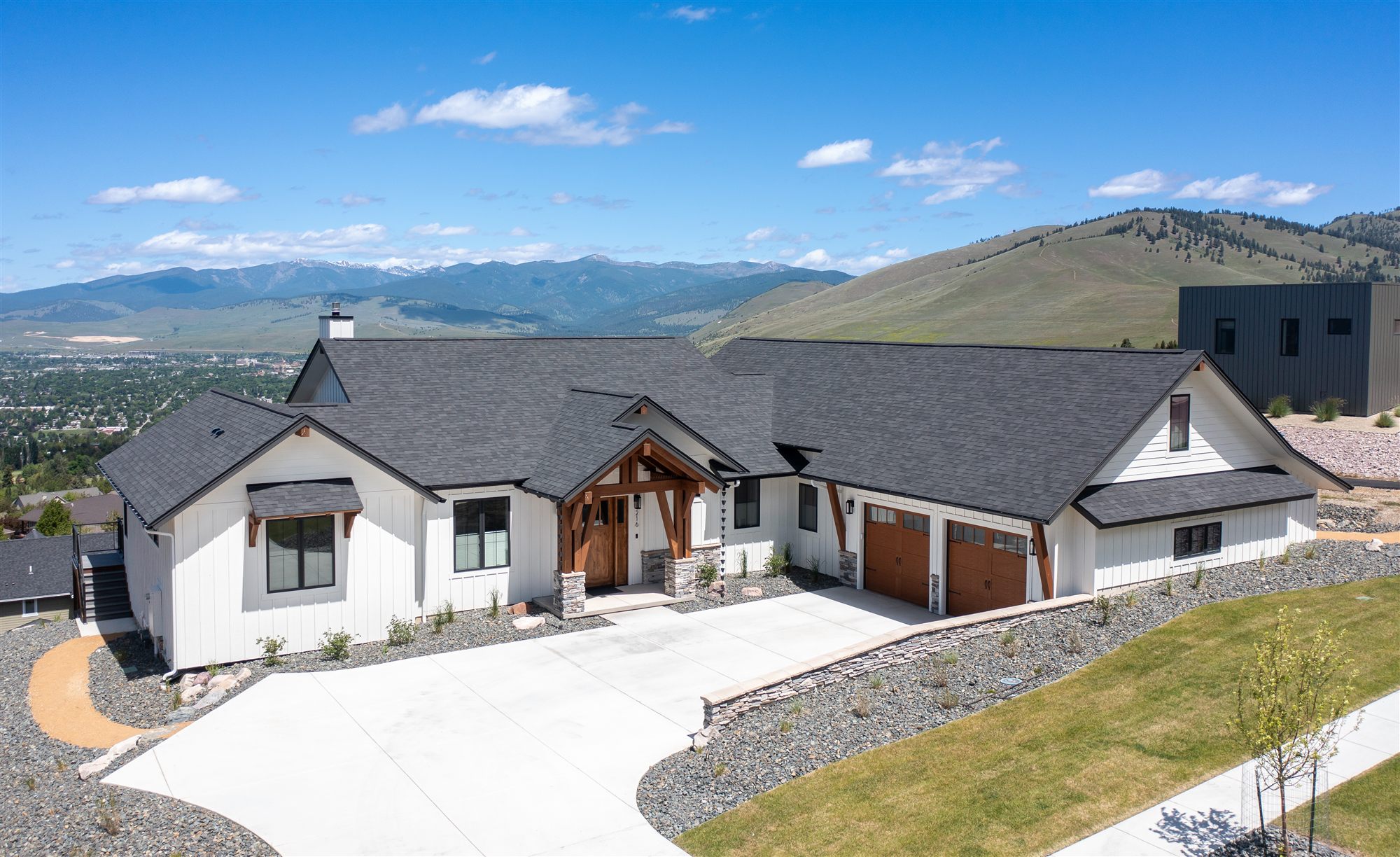 Drone photo of a Missoula hillside home with the valley and mountains behind it, by PMZ Photography