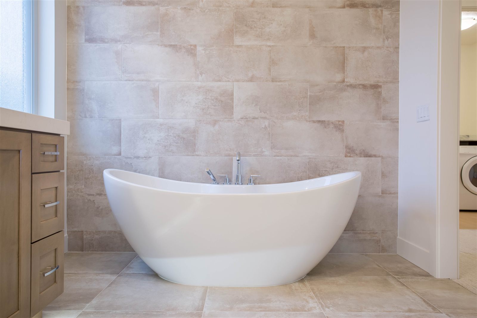 Bathroom with freestanding soaking tub and tile surround