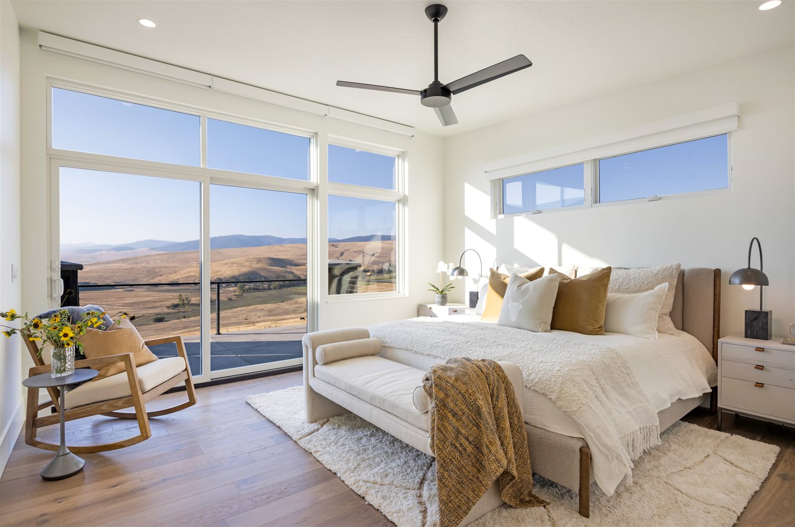 Primary bedroom with floor-to-ceiling windows and Montana views