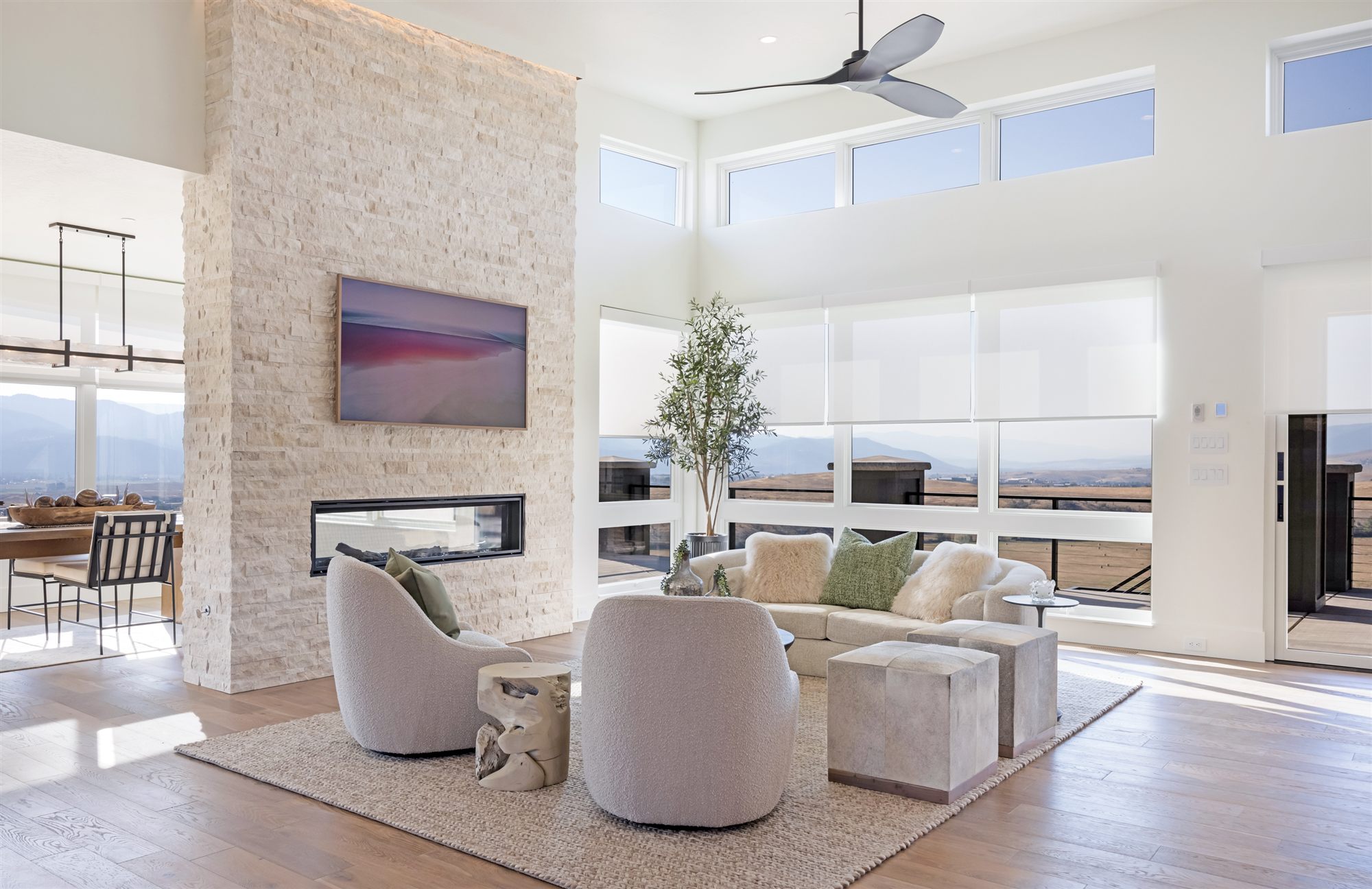 Open-concept Missoula living room with stone fireplace and mountain views, captured for a Matterport 3D tour